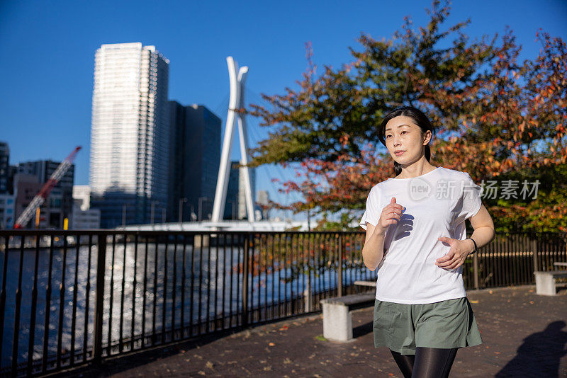 女人在城市的河边奔跑