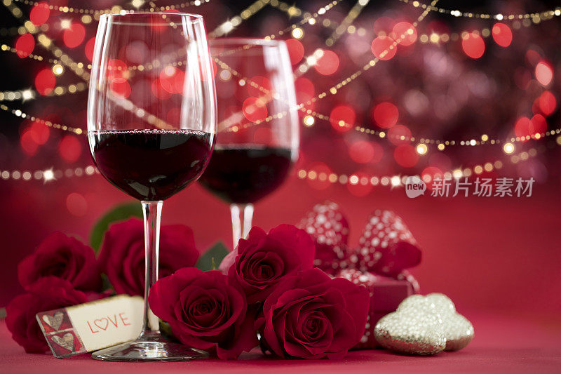 情人节红玫瑰和红酒在散焦的灯光背景
