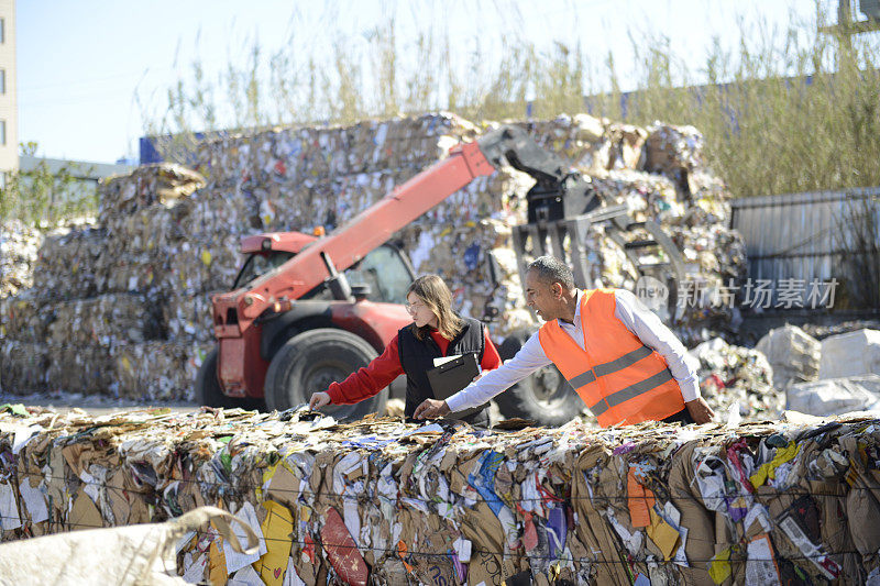 环境工程师及辅助人员在高科技回收设施检查废物