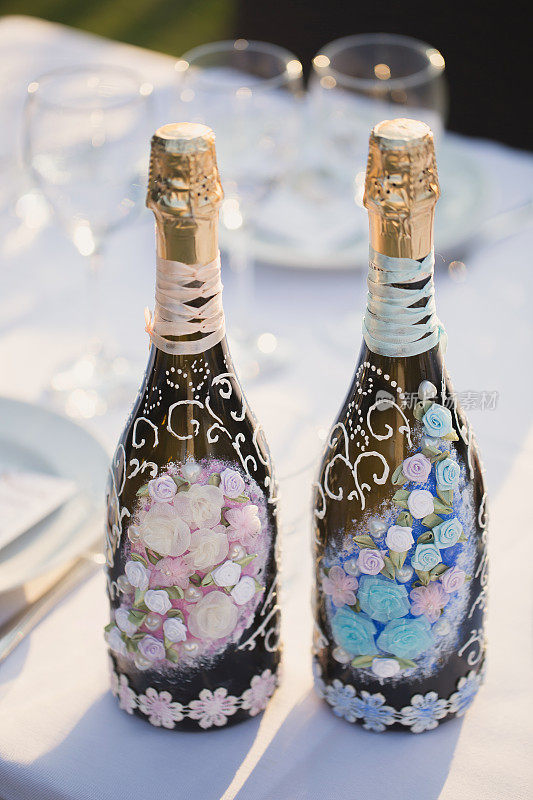 在餐桌上装饰一瓶香槟和起泡酒。婚礼装饰