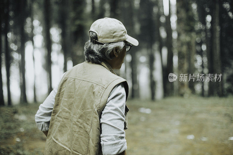 快乐的老人在热带雨林徒步旅行，