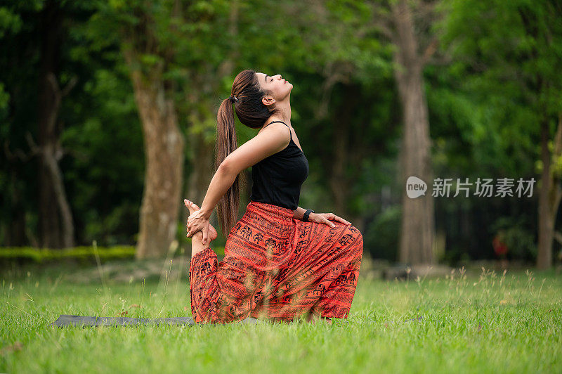 年轻女子在公园户外做瑜伽体式