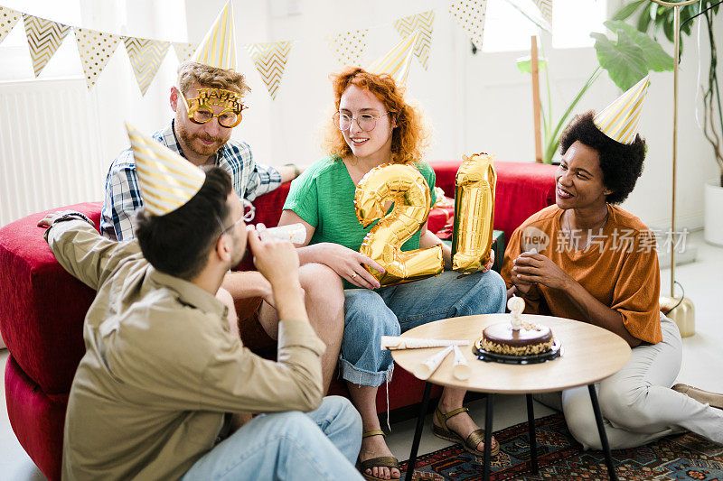 一群年轻人在享受生日聚会，朋友们在生日聚会上玩得很开心