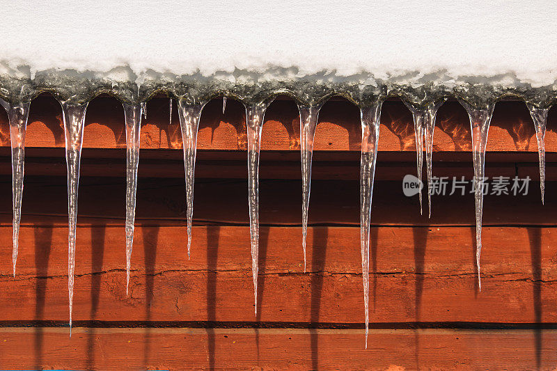 冰柱挂在屋顶上。冬天的背景。天气。气候。冰