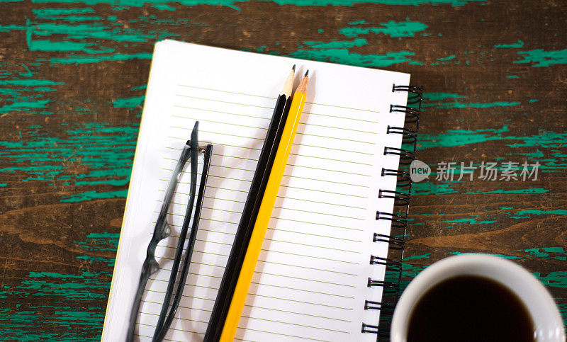 准备工作:笔记本，咖啡，两支铅笔，眼镜，蓝绿色背景