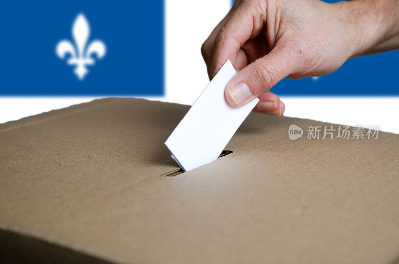 手把魁北克投票卡放入投票箱