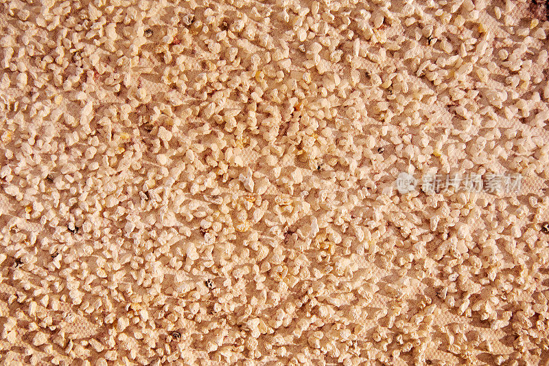 许多石头散落在装饰用的米色石膏层上
