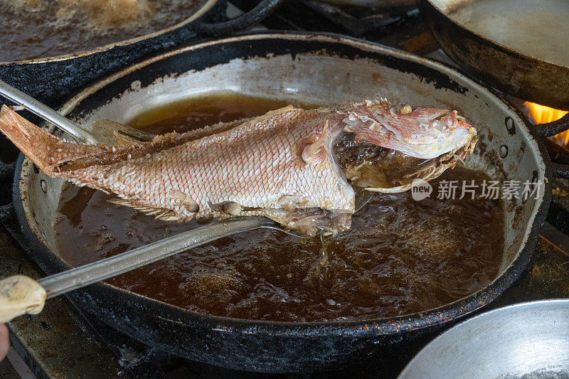 在餐厅的厨房里煎鱼