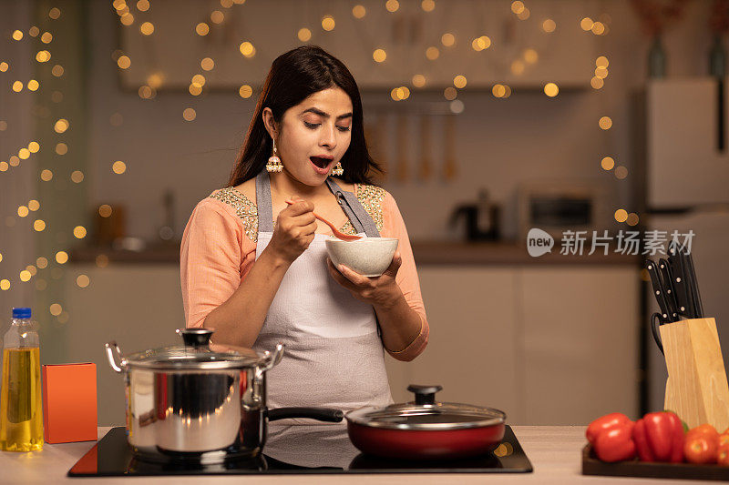 一个年轻女子的肖像烹饪食物在厨房的股票照片