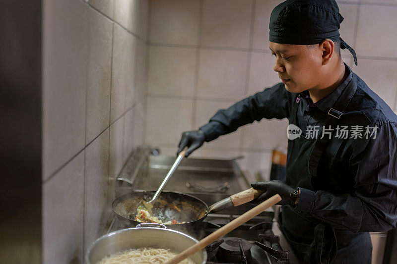 一个穿黑色制服的厨师正在准备饭菜。