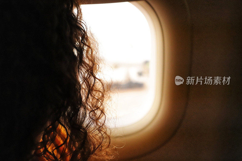 漂亮女人透过飞机的窗户看风景