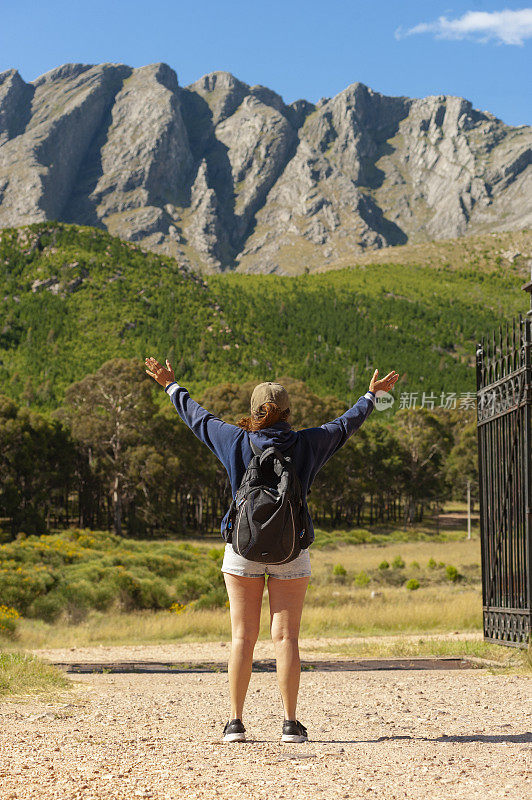 一位中年阿根廷妇女在山前举手