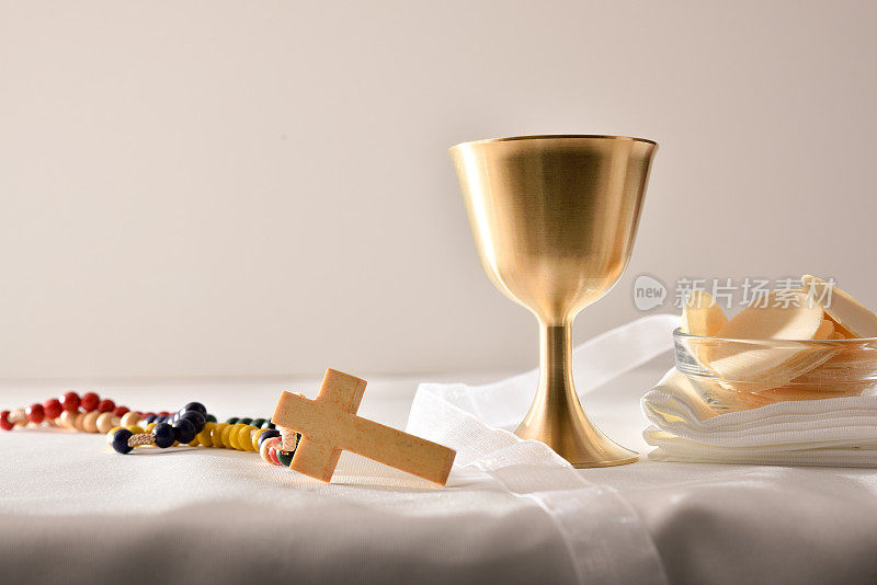 圣杯和神圣的主人在桌子上白色孤立的背景