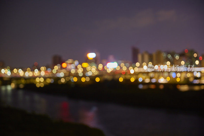 夜间散景灯光，模糊城市景观背景，蓝色调，抽象。