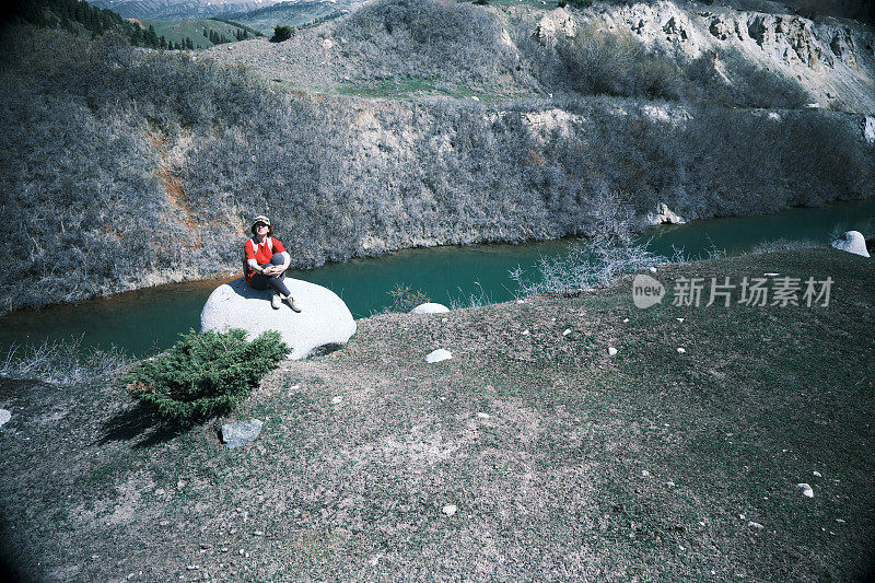 一位女徒步旅行者在山上停下来休息