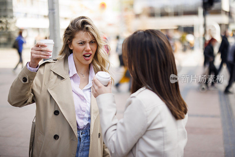 年轻的女性朋友在城市里等公交车时玩得很开心