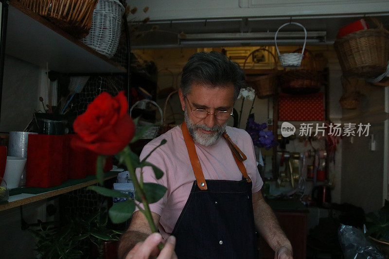留着胡子的男人手里拿着玫瑰花