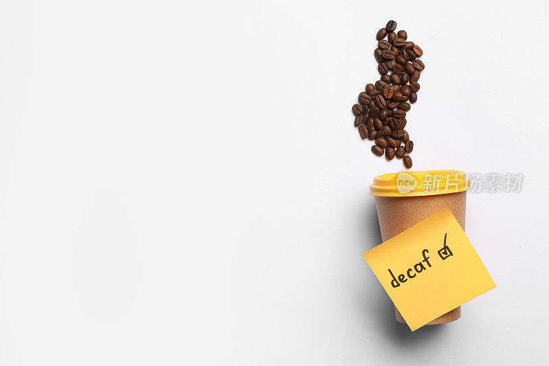 备注与字Decaf附在外卖杯和咖啡豆在白色背景，平躺。文本空间