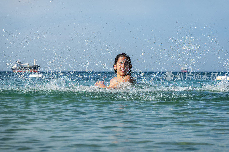 他用手在海里泼水。一个夏天的早晨。忒涅多斯岛。爱琴海北部，12岁的帅哥。长头发的