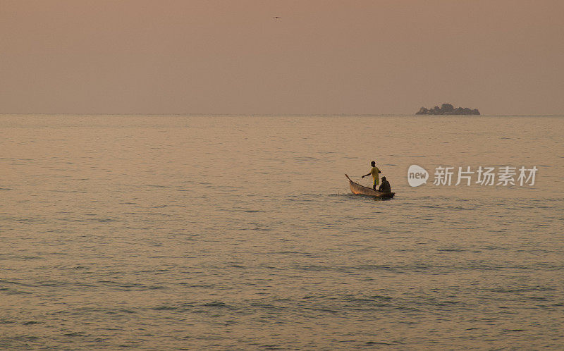 黎明时分，马拉维湖上的渔民坐在独木舟上