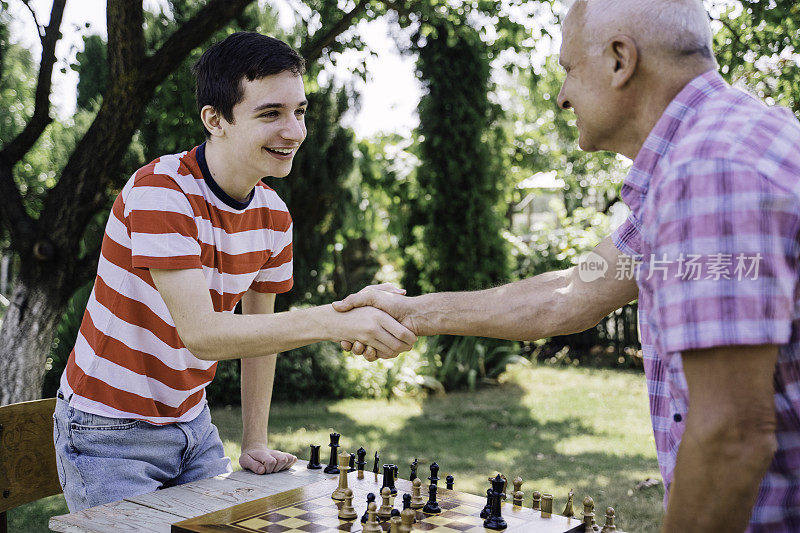 爷爷和孙子在一起下棋。