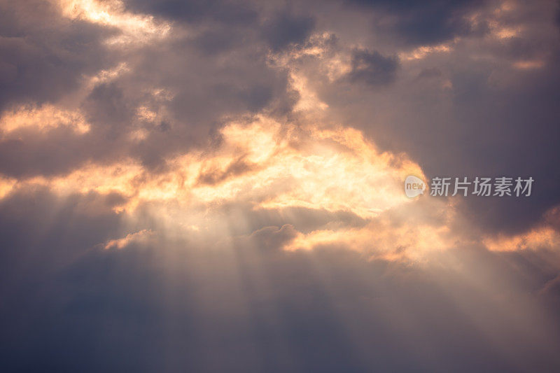 戏剧性的日落天空背景:阳光穿透黑色雷云