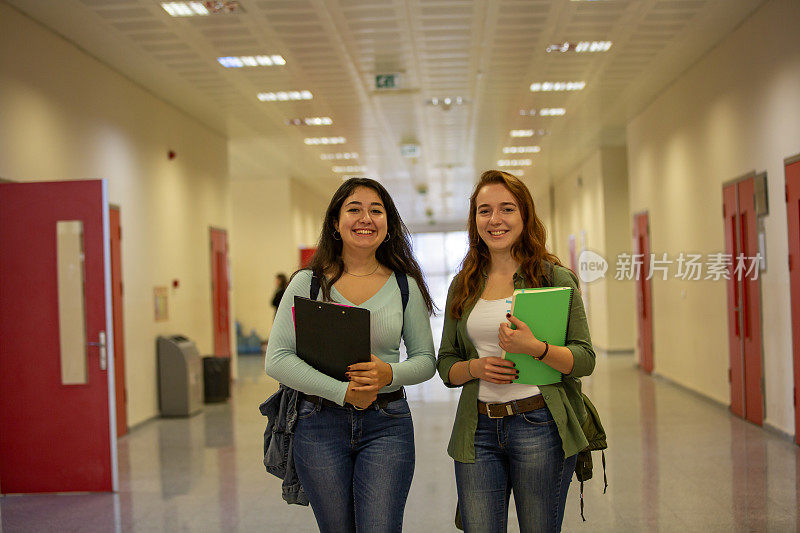课间休息时，快乐的年轻大学生站在走廊上
