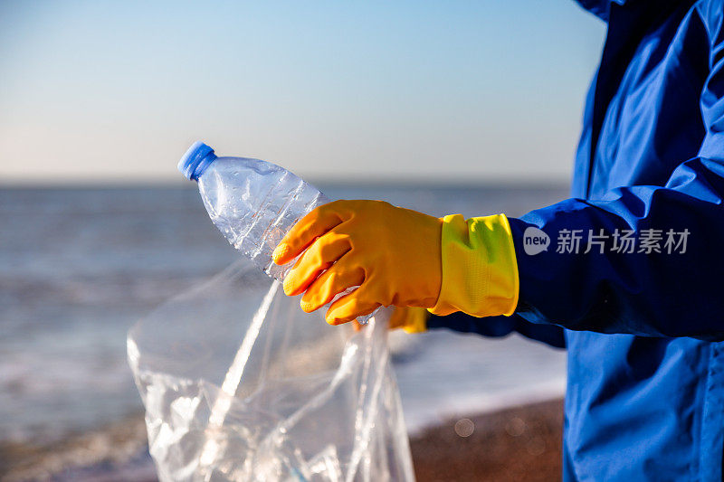 中年男子正在清理海滩上的塑料污染
