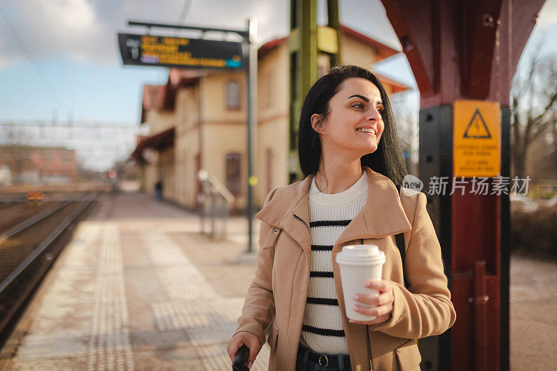 年轻的女商人在火车站等火车