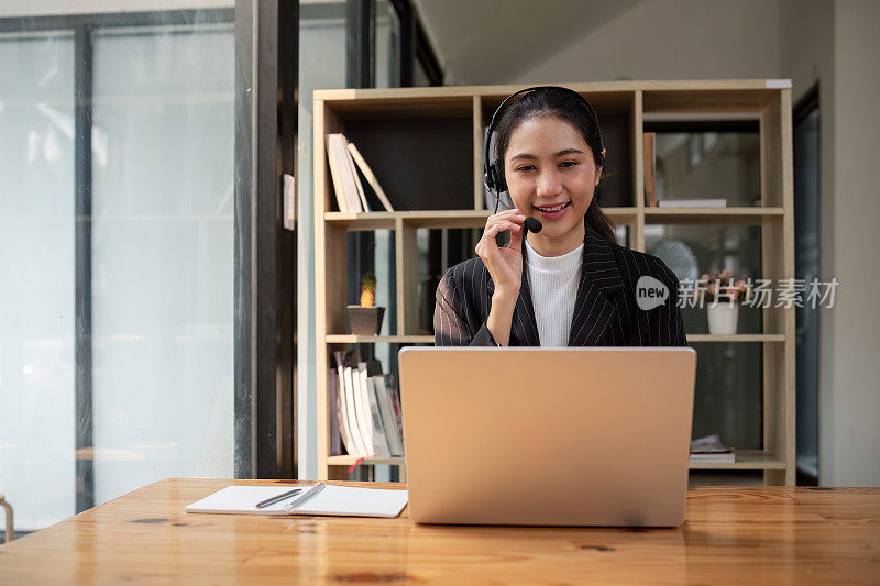 客服中心友好的亚洲女性负责客户服务，技术支持和建议，与客服中心的员工接线员联系和沟通