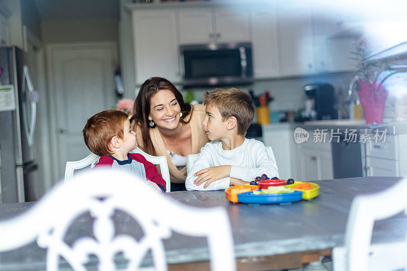 幸福的家庭红发和金发男孩与母亲活跃和满足在家