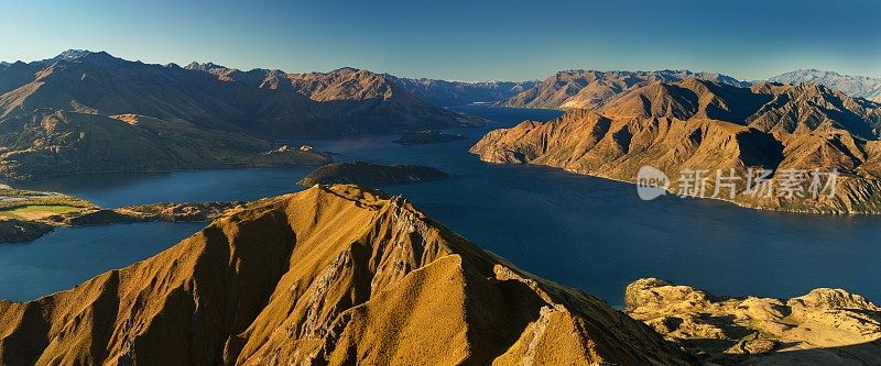 全景在日落的罗伊斯峰之间的瓦纳卡和皇后镇与湖和山的抱负和厨师的新西兰阿尔卑斯山的背景。夏季