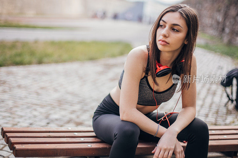 穿着运动服坐在长椅上的少女