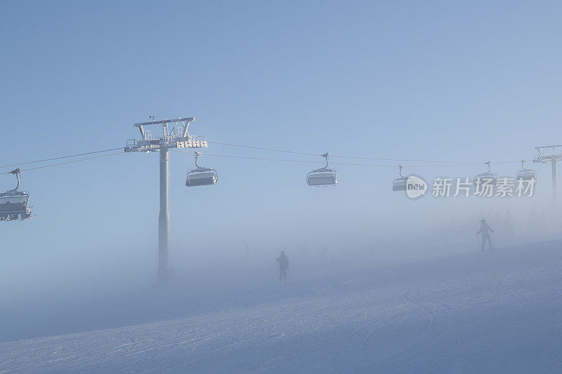 1月一个多雾的日子，在挪威的哈夫杰尔滑雪场，沿着一个滑雪斜坡的滑雪缆车