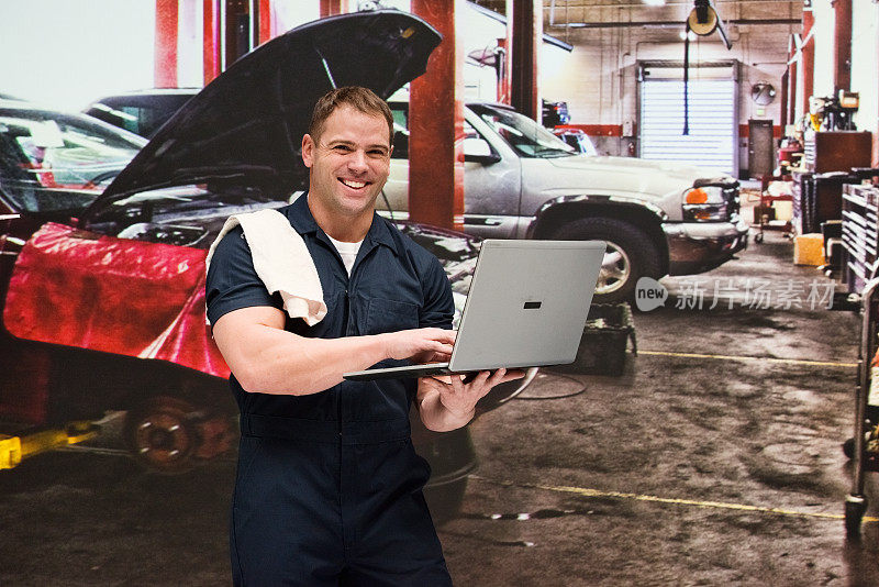 白人年轻男性工人阶级在汽车修理厂修理穿着工作服和使用电脑