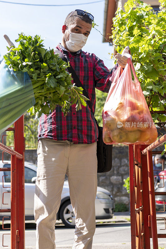 成熟的男人在大流行期间送食品杂货。