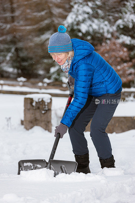 老妇人拿着雪铲