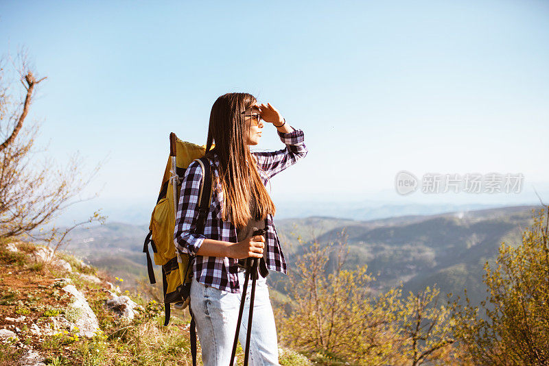 一位年轻的背包客在山顶欣赏风景