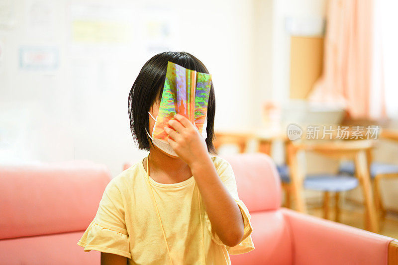 女孩们的肖像戴着面具玩着全息折纸遮住自己的脸