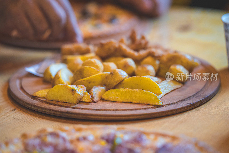 酥脆的鸡块和薯条放在木盘上