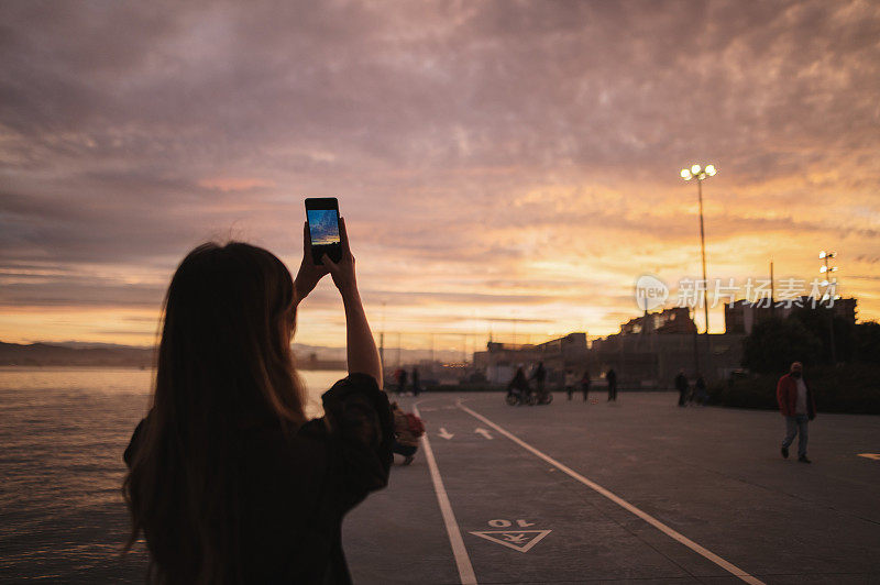 一名年轻女子正在拍摄日落