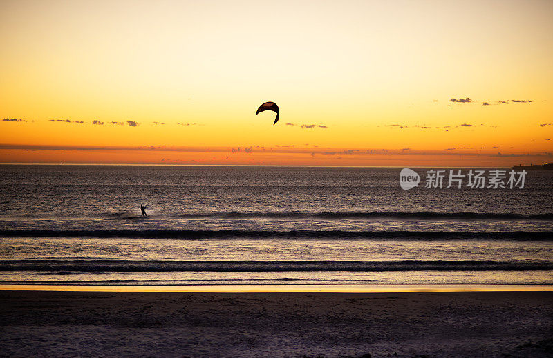 日落时分，在沙滩上冲浪的风筝