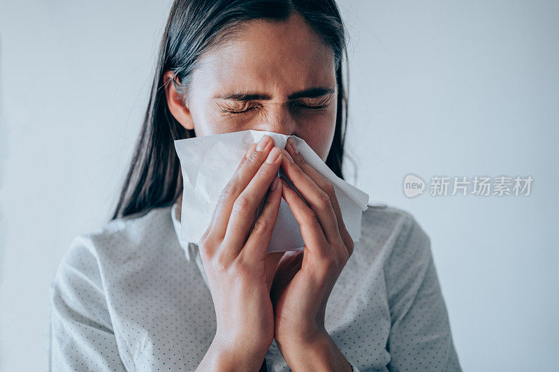 年轻女子在擤鼻涕。