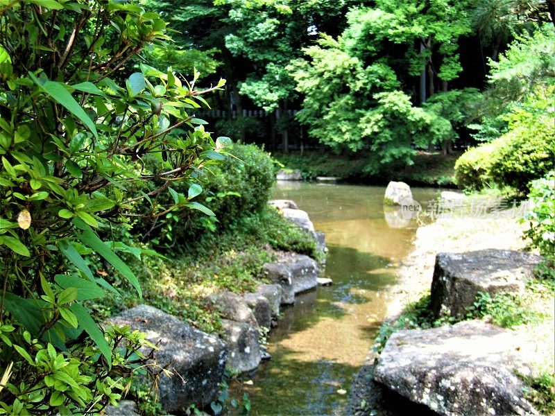 小水流与石头堤岸在传统的日本花园。