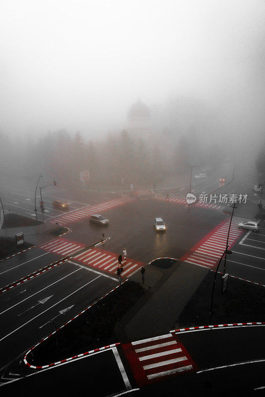 高视角的汽车行驶在繁忙的十字路口在晨雾