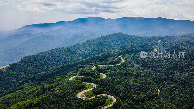 空中山地森林和道路，汽车通过道路，道路穿过树木，风景道路，夏季月空中道路视图，空中道路视图，道路旅行通过森林，背景摄影