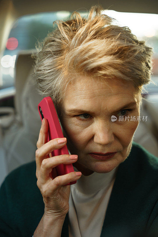 一位严肃的女商人用她的粉色手机拨打Сlose-up