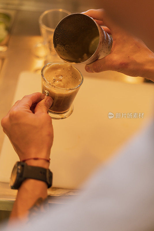 拉丁裔男性餐厅员工为顾客准备一杯美味的咖啡