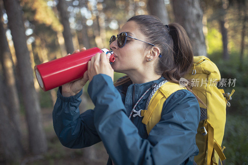 徒步旅行又渴又累，游客喝的是不锈钢瓶装水。