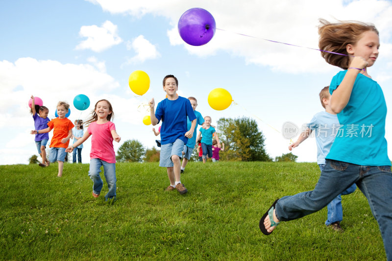 一群快乐的孩子拿着气球奔跑